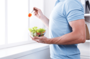 Athletic man eat healthy lunch in modern interior