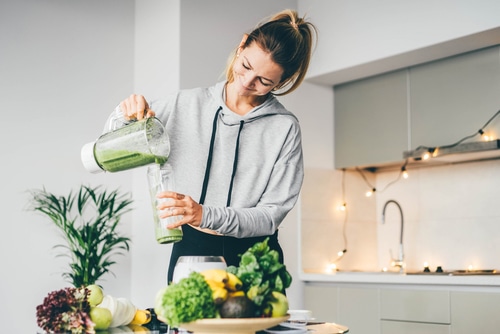 Woman pouring smoothie to glass