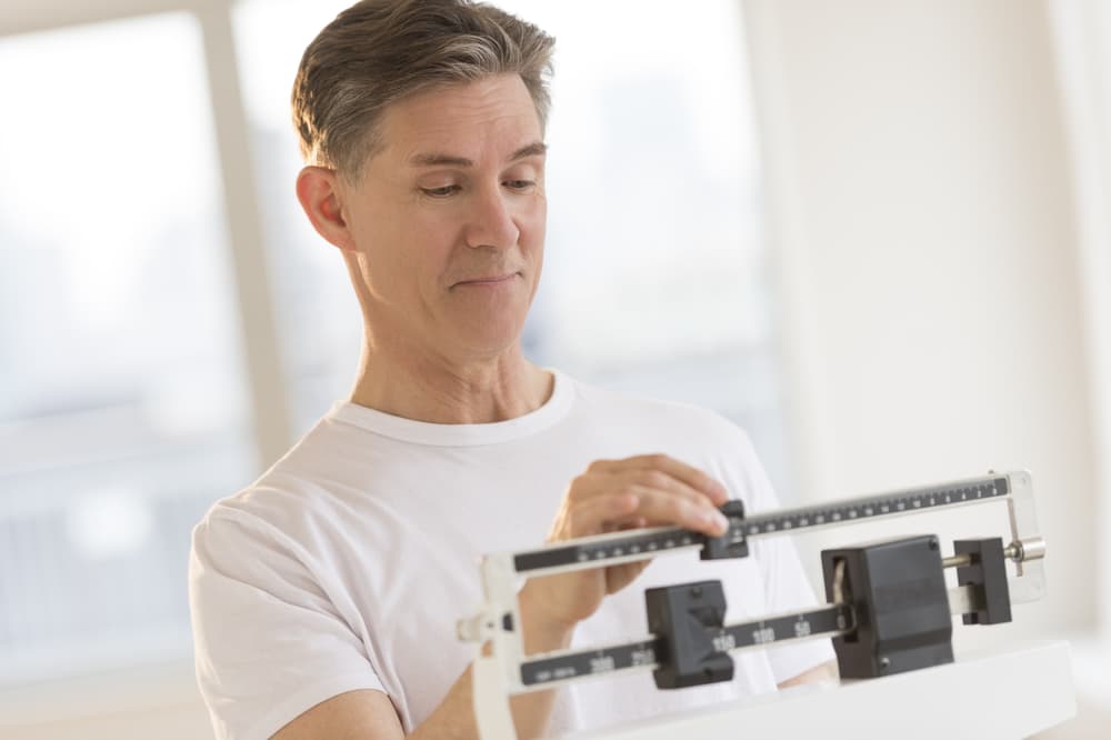 Man Weighing Himself On Balance Weight Scale
