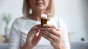 Elderly,Woman,Holding,Bottle,Of,Pills,Close,Up,Focus,On